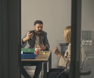 Sakallı adam ve kadın şirket bütçesini tartışıyorlar. Kızgın patron ofisteki muhasebeciye bağırıyor. İşadamları para krizinde finansörü suçluyor. İş çatışması ve çatışma. Tasarruf ve dinleyici dağıtma konsepti