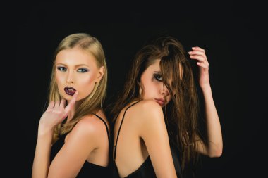 Makyaj ve saç modeli ile moda modelleri. Kuaför ve güzellik salonu. Makyaj göz ve cilt bakımı. Esmer ve sarışın saçlı kız. Kadınlar Siyah izole uzun saçlı. dostluk ve Aile.