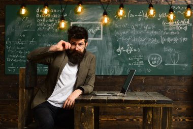 Konuşmacı Üniversitesi toplantı konferans sınıfında, eski kitaplar üzerinde yuvarlak ahşap bir masa eğitim kursu izlemek ve dinlemek dizüstü ekranda görünen adam olarak