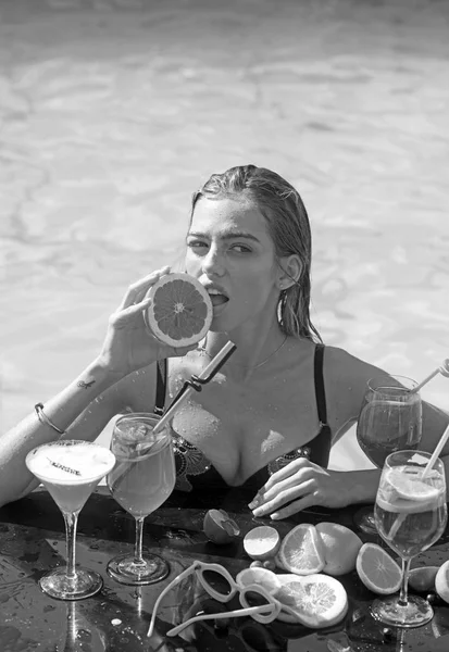 Retrato de uma jovem mulher com um copo de cocktail a arrefecer ao sol tropical na piscina. Conceito de férias . — Fotografia de Stock