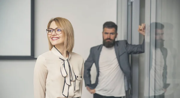 Happy businesswoman with blurred man on background. Sensual woman smile in formal blouse in office. Confident woman with glasses on smiling face. Business fashion and office lifestyle