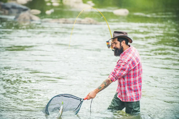 Pesca. Feliz pescador pescando en el río sosteniendo cañas de pescar. Volar pescador hombre en el río. Trucha . — Foto de Stock