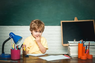Okula ilk kez. Öğretmenler günü - okul kavramı. Tahtayı gösteren komik küçük çocuk. Çocuk okulu.