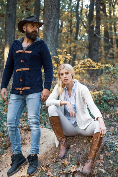 Fashion autumn couple on fall nature background. Autumn love story - portrait couple in love. Autumnal mood. Enjoying nice weekend together. Autumn fashion portrait of couple with autumnal mood.