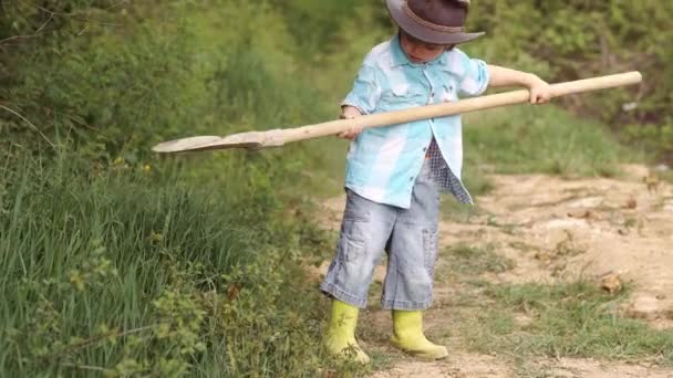 Criança e legumes na fazenda. Retrato de corpo inteiro de um menino plantando em uma fazenda. Eco vida. Conceito infantil. Um pequeno agricultor a plantar na aldeia. Vida agrícola americana . — Vídeo de Stock