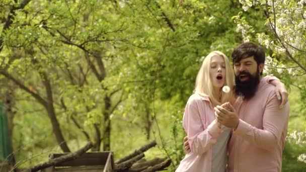 Couple agriculteur dans la ferme avec fond de campagne. Jour de la Terre. Belle femme et bel homme à l'extérieur dans les arbres en fleurs. Couple de printemps dans le jardin fleuri. Couple de jeunes agriculteurs - concept de vie écologique . — Video