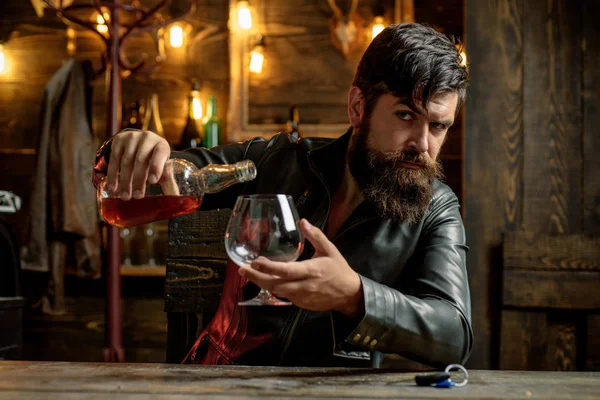 Sommelier chutná alkoholově nápoj. Muž pije brandy nebo whiskey. Vousatý muž nosí oblek a pije whisky s koňaku. To je pro pití a párty. Degustace a ochutnávka. — Stock fotografie