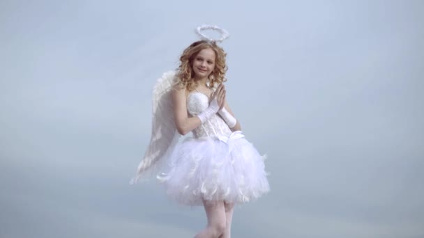 Angel szárnyak baba imádkozni. Szerelmi koncepció. Aranyos tini Cupido a felhő-ég háttérben. Angyal gyermek lány göndör szőke haja-ártatlan lány fogalmát. Imádkozni.