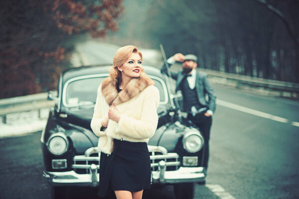 Travel and business trip or hitch hiking. Retro collection car and auto repair by mechanic driver. Escort of girl by security. Bearded man and sexy woman in fur coat. Couple in love on romantic date.