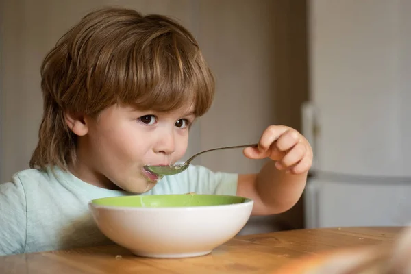 Evde sağlıklı yemek yiyen çocuk çocuk. Mutlu çocuk kahvaltı eder. Evde kahvaltı güzel çocuk portresi. Mutfakta meyve püre yiyen mutlu sevimli bebek gülümseyen. Çocuk yeme. — Stok fotoğraf