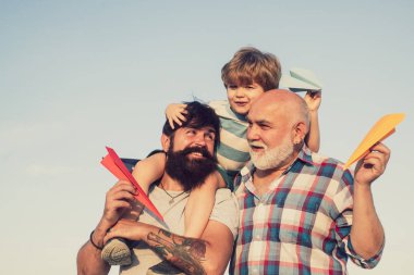 Aile nesil: gelecek rüya ve insanlar kavramı. Baba ve dedesi olan çocuk. Erkek çok nesil portre. Seyahat kağıt uçak hayalleri ile çocuk pilot Aviator.