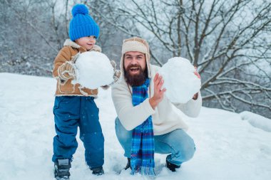 Mutlu baba ve oğul kış Noel zaman oyun. Güneşli kış gününde mutlu gülümseyen aile. Dostça aile konsepti.