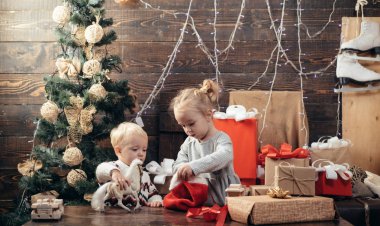 Ahşap arka planda Noel hediyesi olan çocuk. Kış çocukları. Çocuk tatilden keyif aldı. Noel kartı. Yeni yıl çocukları. Noel hediye kutusu ile mutlu çocuk.