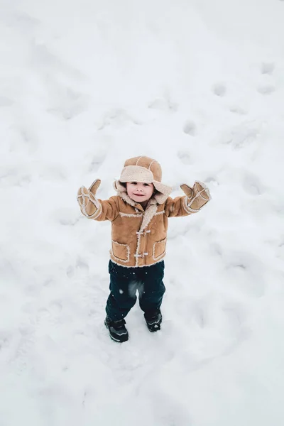 冬服のかわいい男の子。子供のための雪玉と冬の楽しみを作ります。雪の冬の散歩に雪と遊ぶ幸せな子供。自然の冬を楽しむ. — ストック写真