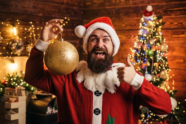 Gekke, grappige Hipster Kerstman. Portret van de gelukkige Kerstman met decoratieve speelgoed ballen in de buurt van de kerstboom. Gelukkig Kerstman gekleed in winterkleding denk aan Kerstmis of Nieuwjaar. — Stockfoto