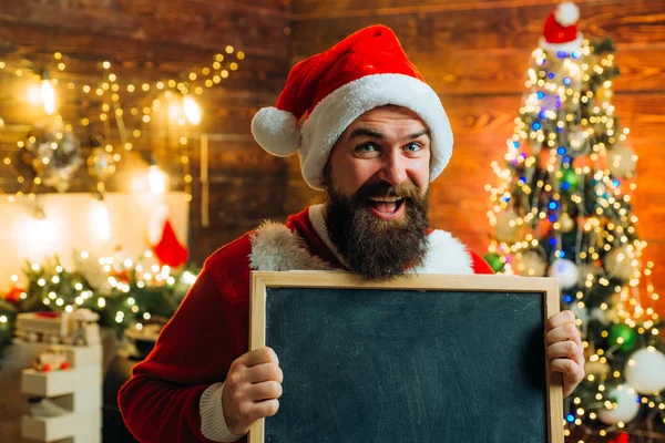 Novoroční módní oblečení. Téma Vánoční svátky a zimní nový rok. Muži v zimním oblečení. Šťastný Santa oblečený v zimním oblečení přemýšlet o Vánocích v blízkosti vánočního stromečku. — Stock fotografie