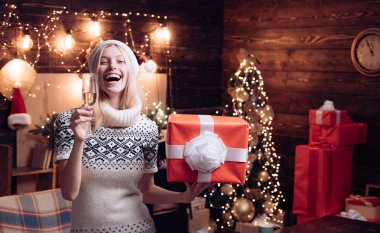 Kadın rahat örme kazak evde noel atmosferi tadını çıkarın. Noel geliyor. Ev iç noel ağacı dekorasyon. Kız kış giysileri noel baba şapka noel ve mutlu yeni yıl kutlamak
