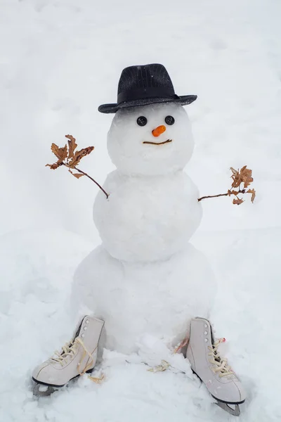 Snowman the friend is standing in winter hat and scarf with red nose. Snowman and snow day. Winter scene with snowman on white snow background. Snow men.