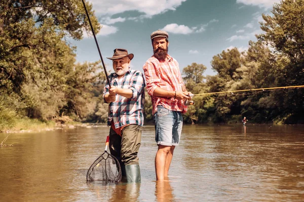 Pesca a mosca della trota. Padre con figlio sul fiume godendo pesca azienda canne da pesca . — Foto Stock