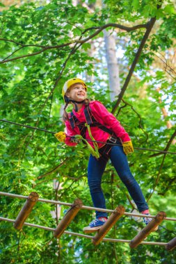 Toddler bir ip oyun alanı yapısında tırmanma. Çocuklar yaz aktiviteleri. Yürüyüş ve çocuk konsepti. Kask ve güvenlik ekipmanları. Halat parkı. Çocuk kavramı.