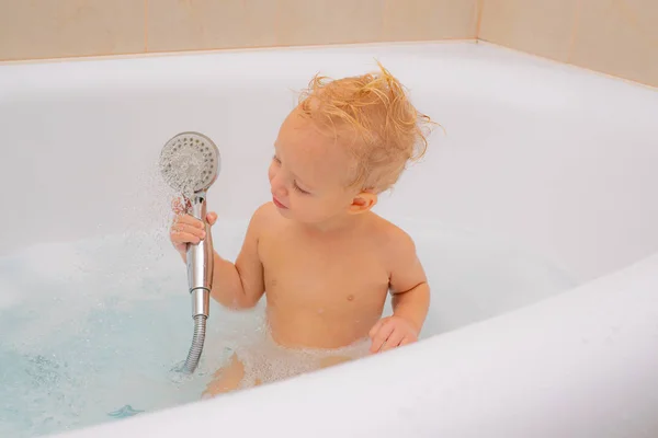 Baño de burbujas. Niño sonriente bañándose bajo una ducha en casa. Educación en pureza e higiene . —  Fotos de Stock