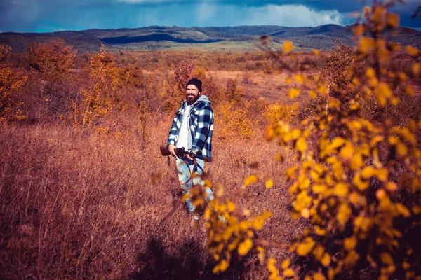 Chasseur avec fusil de chasse en chasse. Saison de chasse d'automne. Braconnier avec fusil repérant des cerfs. Chasse illégale braconnier dans la forêt. — Photo