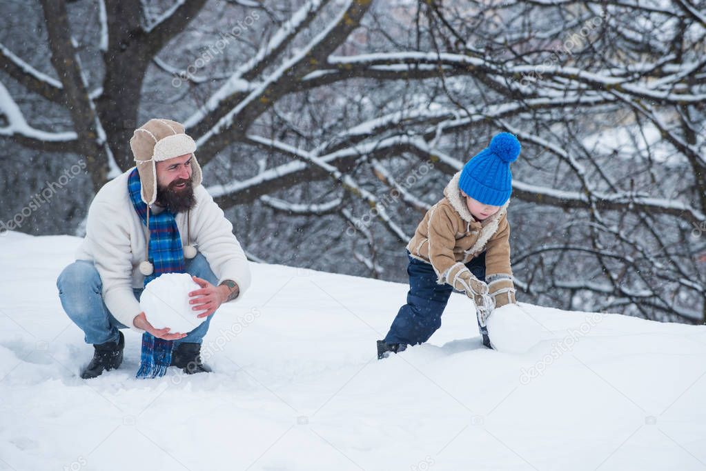 Merry Christmas and Happy New Year. Father and son play in winter clothes. Winter family in frosty winter Park.