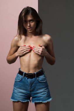 Sütyensiz stüdyoda seksi model. Kırmızı tırnaklı güzel kadın.