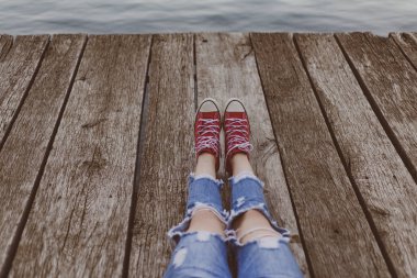 Kırmızı spor ayakkabılarla oturan üzgün emo. Ergenlik sorunları. Genç rüya ve yalnızlık zamanı. Okula geri dön.