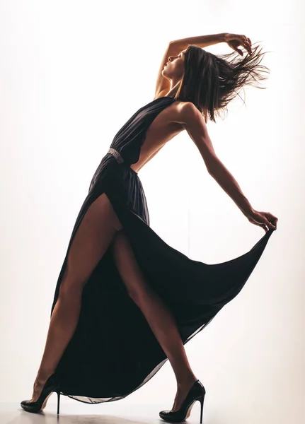 Элегантная горячая девушка танцует. Движение. Женщина в черном платье . — стоковое фото