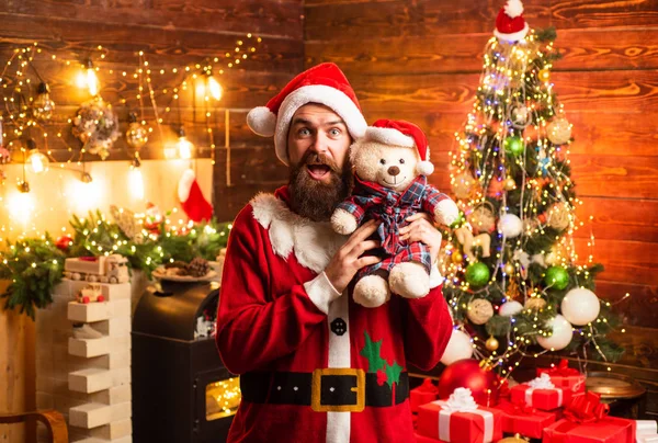 Hipster Kerstman thuis. Bearded man met plezier in de buurt van kerstboom binnenshuis. Home kerstsfeer. Mannen in winterkleren. Santa winter portret. — Stockfoto