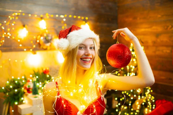 Fête de Noël. Yang et une femme blonde sexy en lingerie rouge montrant des boules de Noël . — Photo