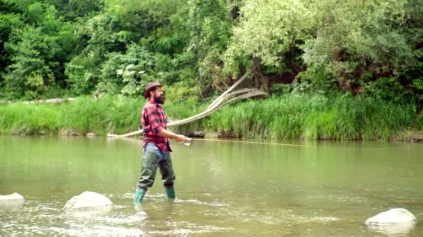 茶色のマスを持ってるまだ水マス釣り。スチールヘッド・ニジ・マス釣りは人気のレクリエーション活動になりました。フライフィッシング。美しい川でフライフィッシングロッドを使用してフライ漁師. — ストック動画