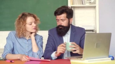 Öğrenciler ve eğitim konsepti. Üniversitede öğrenci. Üniversite okuyan komik öğrenciler çift. Yeşil kara tahta arka planda kadın öğrenci ile genç erkek öğretmen.