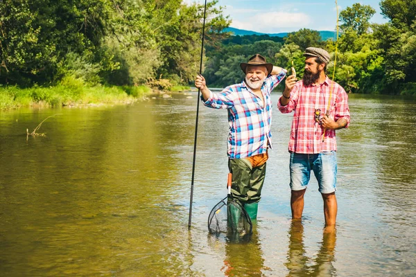 Volar pescador en el río. Pesca en el río. Pesca en el río. Pescador mosca usando caña de pescar mosca en hermoso río. Padre e hijo de pesca . —  Fotos de Stock