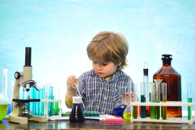 Okulun laboratuarında kimya dersi alan küçük çocuklar. Kimyada öğretilenler. Laboratuvar mikroskobu ve test tüpleri. Okul konsepti. Okula ve evde eğitim görmeye.