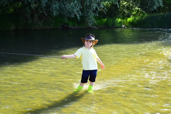 Piccolo bambino che pesca sul fiume. Pescatore bambino utilizzando canna da pesca nel bellissimo fiume. Bambino imparare a pescare tenendo una canna su un fiume . — Foto Stock