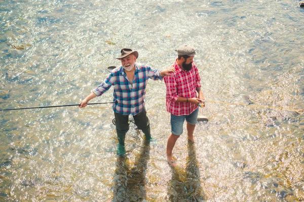 Balıkçılık popüler bir eğlence aktivitesi haline geldi. Balıkçı ve kupa alabası. Avrupa 'nın bozulmamış vahşi içinde Balıkçılık Fly. Baba ve oğul birlikte rahatlatıcı. Fener. — Stok fotoğraf