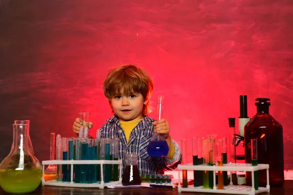 School chemistry lessons. School concept. Child in the class room with blackboard on background. Child from elementary school. A chemistry demonstration. Chemistry science.