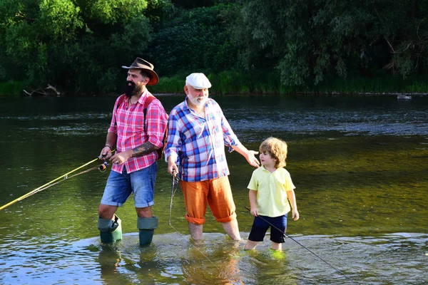 Fishing became a popular recreational activity. Summer weekend. Fly fisherman using fly fishing rod in river. Generations men.