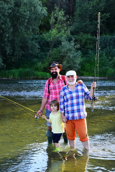 Großvater und Vater mit niedlichem Jungen angeln. Familienbande. Vater, Sohn und Großvater angeln. Männertag. — Stockfoto