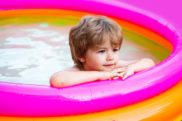 Los niños aprenden a nadar. Actividad deportiva al aire libre saludable para niños. Niño feliz nadando en una piscina. Niña divirtiéndose en la piscina. Niño feliz divirtiéndose en la piscina en un día soleado . —  Fotos de Stock