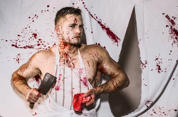 Steak ou beefsteak - viande sanglante. Du sang éclaboussé. Un jeune homme tient un couteau dans les mains et des tranches de viande. Fausse imagination de masculinité. — Photo