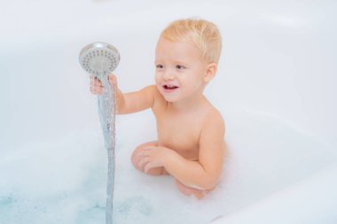 Bebek sabun ile banyoda eğlenin. Saflık ve hijyen eğitimi. Mutlu küçük bebek oğlan sahip olan eğlence için banyo.