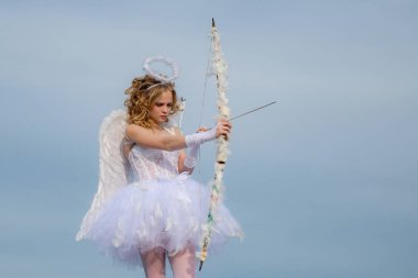 Bulut-gökyüzü arka planda sevimli genç Cupid. Sevgililer günü. Güzel çocuk. Bir ışık arka planda bir melek gibi giyinmiş Sevgililer Daygirl kavramı