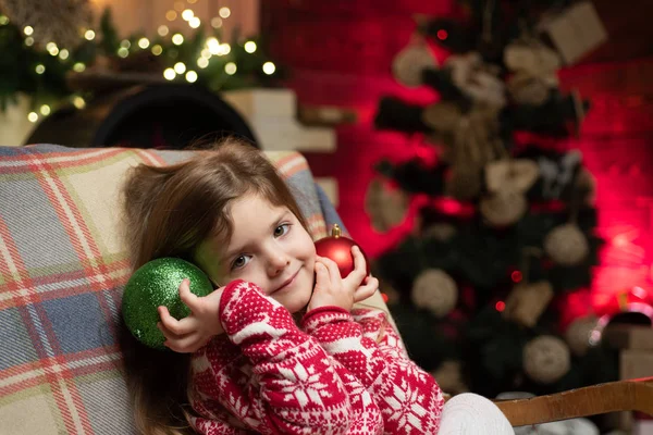 Roztomilá holčička si hraje na vánoční stromek. Děti si doma užijí zimní prázdniny. Domov naplnil radost. Útulná vánoční atmosféra. Dívčí Štědrý den. Veselé Vánoce a šťastný nový rok — Stock fotografie