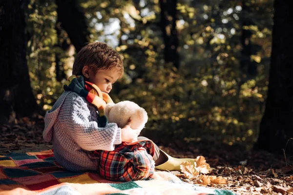 Niño llevó juguete favorito a la naturaleza. Picnic con osito de peluche. Senderismo con juguete favorito. Mejor juntos. Feliz infancia. Inseparable con juguete. Niño lindo niño jugar con osito de peluche juguete bosque fondo —  Fotos de Stock