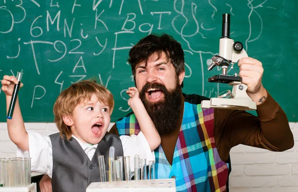 선생님은 학생들의 숙제를 학교에서 돕습니다. 교실에 있는 아이와 선생님. 행복 한 작은 과학자가 시험관으로 실험을 하는 모습. — 스톡 사진