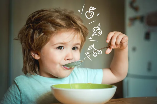 Lachen schattige kind baby jongen zittend in kinderstoel en eten op onscherpe achtergrond. Vrolijk baby kind eet zelf eten met lepel. Ouderschap. Kleine jongen zittend aan de tafel en het eten van melk snack. — Stockfoto