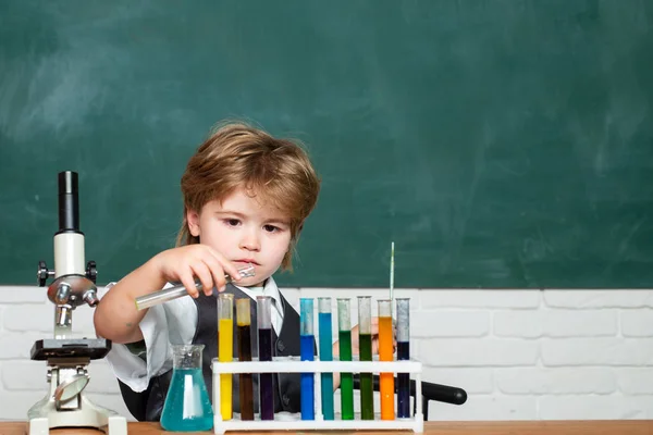 Chimica. La classe di scienze. Microscopio da laboratorio e provette. Piccoli bambini a scuola. Lavagna per testo di spazio di copia. Scuola elementare. Pronti per la scuola. Scuola materna — Foto Stock